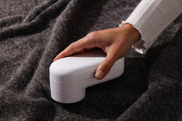 Fototapeta premium Machine for shaving fabric on clothes, on a dark background.