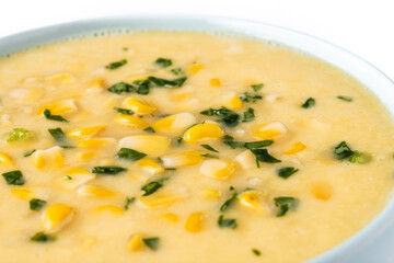 Corn soup in green bowl on white marble. Close up