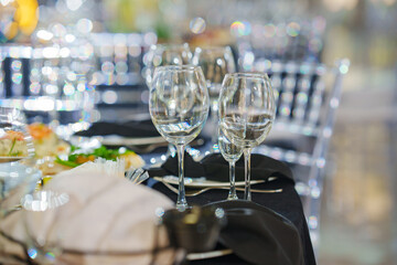 Empty wine glasses on a table with a black tablecloth. 