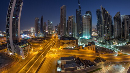 Fototapeta premium Aerial panorama of Dubai Downtown skyline with many towers night to day timelapse.