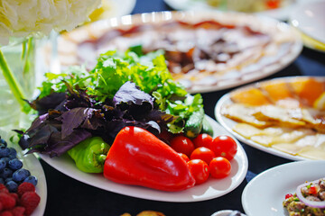 Banquet table with black tablecloth served with appetizers. vegetables