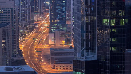 Aerial view from above to a busy road intersection in Dubai night to day timelapse.