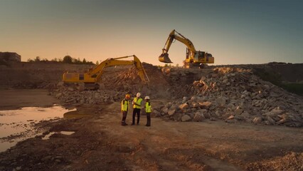Aerial Drone Shot Of Construction Site With Excavators On Sunny Day: Diverse Team of Real Estate Developers Discussing Project. Engineer, Architect, Inspector Talking About New Building, Using Tablet. - Powered by Adobe