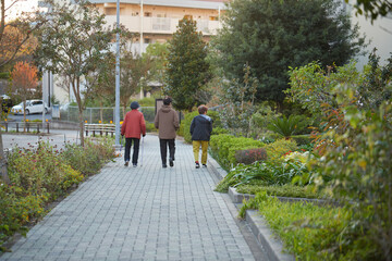 Fototapeta na wymiar 秋の住宅街の街で散歩しているシニア女性たちの姿