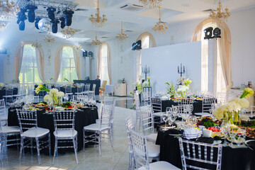 Beautifully set banquet tables. Snacks, flowers and wine glasses.