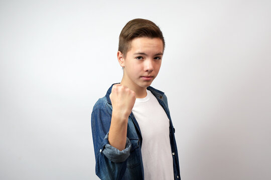 Angry boy showing his fist and looking camera.