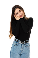 Portrait of friendly young waman keeps hands pressed together under chin, looks with happy expression, isolated on white background. Twenty year old girl in black turtleneck smile and posing in studio