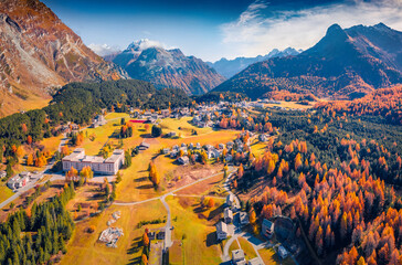 Breathtaking autumn view from flying drone of Maloja village. Colorful morning scene of Swiss Alps,...