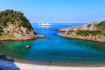 Obraz premium 式根島の美しい泊海水浴場と沖を行く東海汽船さるびあ丸。東京都伊豆諸島式根島にて。 2023年11月1日〜5日撮影。 水中写真。Tokai Kisen ship Sarubia Maru goes offshore with the beautiful Tomari Beach on Shikinejima.At Shikinejima, Izu Islands, Tokyo. Phot