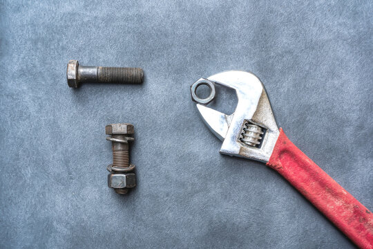 Wrench, hex bolt and hex nut on leather floor.