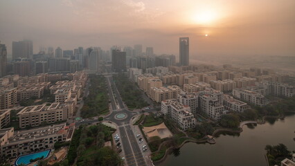 Skyscrapers in Barsha Heights district and low rise buildings in Greens district aerial night to...