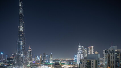 Fototapeta premium Panorama showing aerial cityscape night timelapse with illuminated architecture of Dubai downtown.