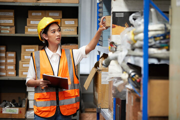 factory worker holding a clipboard and looking at shelf in warehouse storage - obrazy, fototapety, plakaty