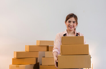 Portrait of starting a small business SME business owner Female entrepreneur working on merchandise boxes Receipts and checks online orders to prepare boxes for seller to customers.