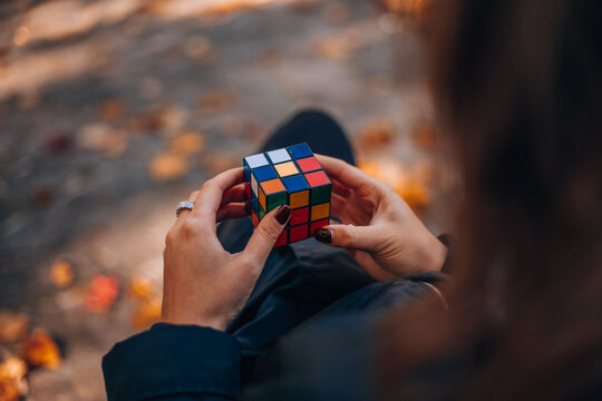 Cube Puzzle Challenge: A person focuses intensely on solving a Rubik's Cube.