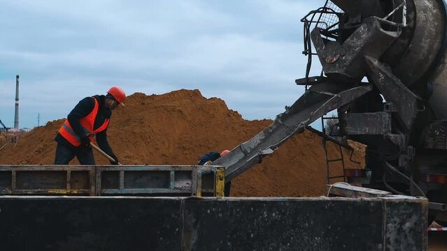 A concrete mixer truck pours cement concrete. Industrial construction. Pouring the foundation