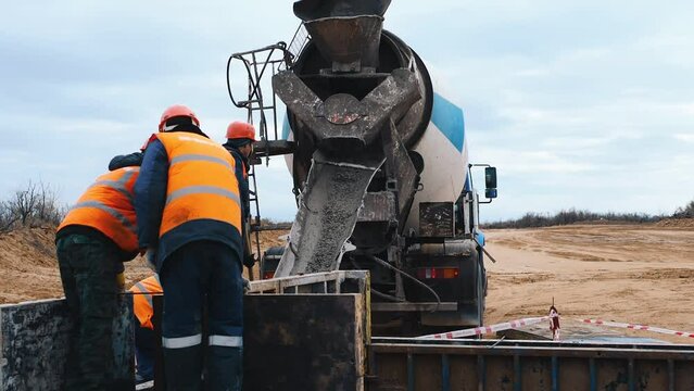A concrete mixer truck pours cement concrete. Industrial construction. Pouring the foundation