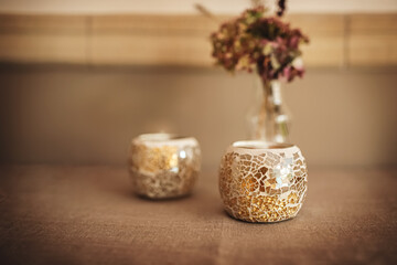 Fototapeta na wymiar Dekoration aus zwei Teelichter Untersetzer und trockenen Blumen.
