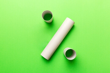 Empty toilet paper roll on colored background. Recyclable paper tube with metal plug end made of...