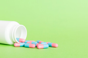 plastic medicine bottle with capsules of pills on colored background. Online pharmacy. Painkiller...