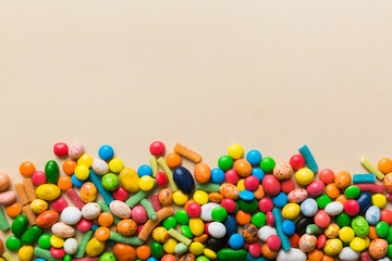 Mixed collection of colorful candy, on colored background. Flat lay, top view. frame of colorful chocolate coated candy