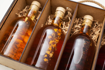 Bottles with expensive homemade alcoholic drink brandy and cognac in a wooden box, close-up, wineshop