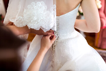 A Bride Preparing for Her Special Day , A bride is putting on her wedding dress