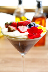 Chocolate mousse dessert, cocktail in a glass, decorated with fresh fruits, selective focus, with blurred background.
