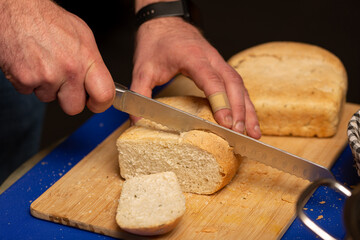 A man cuts fresh hot bread