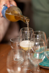 Sommelier pours white sparkling wine into a glass