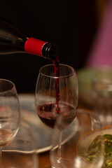 Sommelier pours red wine into a glass during tasting