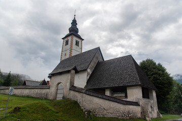 Fototapeta na wymiar A view towards the church of Saint Paul in the alpine village of Stara Fuzina