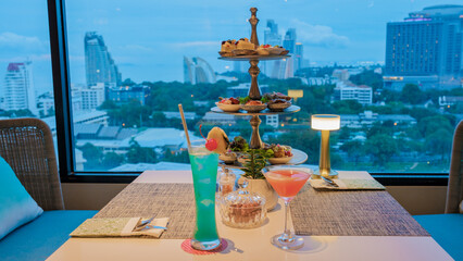 rooftop bar in Pattaya Thailand with cocktails and snacks by the window looking out over the city in the evening in Pattaya Thailand