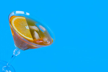 Aperol spritz cocktail in martini glass on the blue background. Copy space. Close-up.