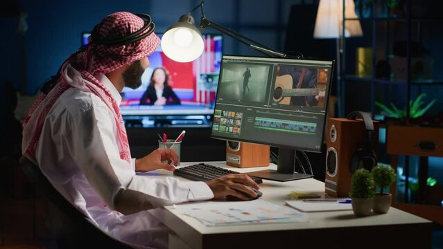 Arabic cinematographer in home office editing project using filmmaking techniques, working with footage and sound. Middle Eastern man using videography software to process movie on workstation