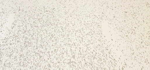 The cement walls have polka dots all over the area. Dirty marks on the cement wall are caused by...