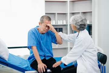 Obraz premium Asian doctor in white suit take notes while discussing and Asian elderly, man patient who lying on bed with receiving saline solution