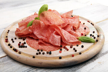 thinly sliced salami, delicious snack rustic salami on table - 677630544