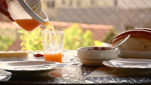 serving fresh orange juice on a breakfast table on a sunny day