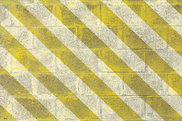 Bandes jaunes sur mur de parpaings peint en blanc 