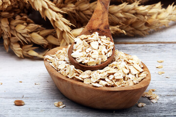 Oat flakes or rolled oats and golden ears of wheat. Healthy lifestyle, healthy eating, vegan diet...