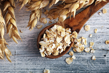 Oat flakes or rolled oats and golden ears of wheat. Healthy lifestyle, healthy eating, vegan diet concept