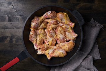 Seasoned chicken drumsticks in a wok