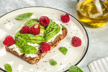 Avocado Toast for breakfast or lunch with avocado, raspberries, cream cheese and chia seeds. Vegetarian food. Clean eating. Top view. Copy space