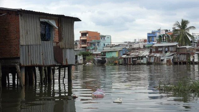Polluted water and riverside homes made of corrugated sheets, in a poor neighborhood in the suburbs of Saigon, Vietnam
