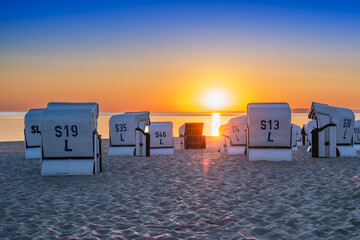 Sunrise on the beach by the Baltic Sea with beach chairs - obrazy, fototapety, plakaty