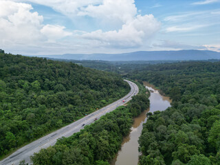 Aerial photography showing beautiful rivers and mountainside roads. Transportation concepts.