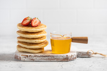 stack of pancakes with strawberries and honey