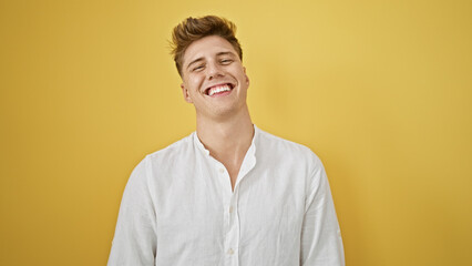 Laughing, confident young caucasian man in casual fashion, standing isolated against a yellow...