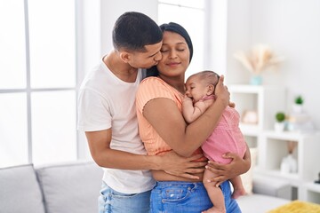 Fototapeta premium Hispanic family hugging each other kissing at home